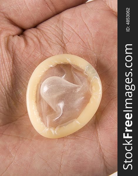 Mans hand holding latex condom. Mans hand holding latex condom