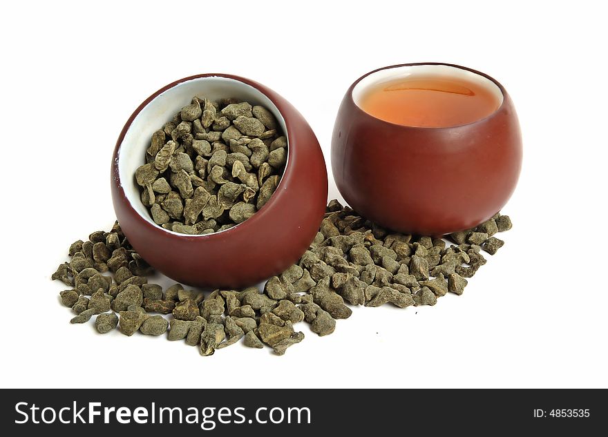 Cup of dried green tea leaves with ginseng and cup of tea. Cup of dried green tea leaves with ginseng and cup of tea