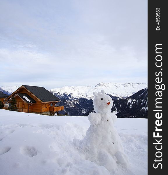 Snowman and chalet in winter