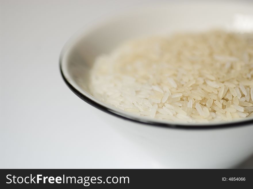White bowl with rice on a white surface. White bowl with rice on a white surface