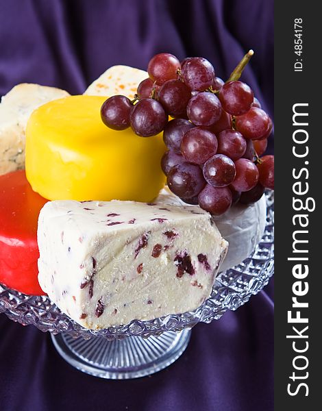 Cheese and grape selection with a purple background