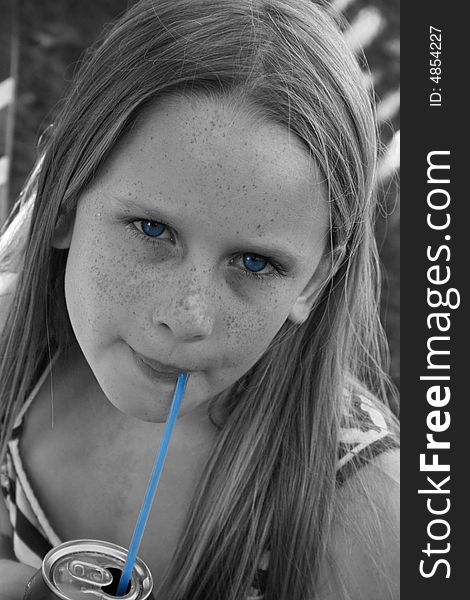 A white caucasian girl child sipping on cooldrink through a straw. A white caucasian girl child sipping on cooldrink through a straw