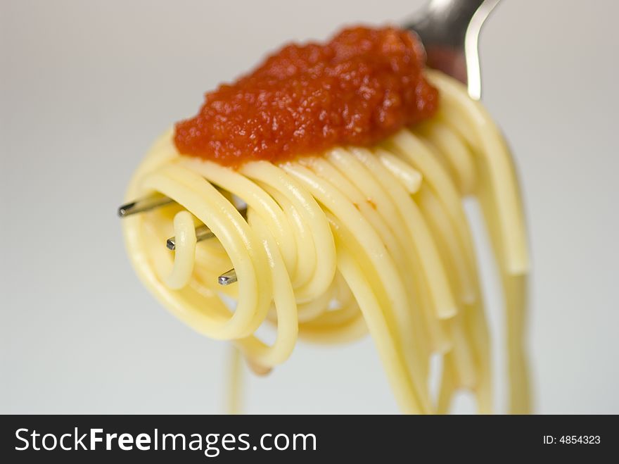 Metal fork with spaghetti and tomato sauce
