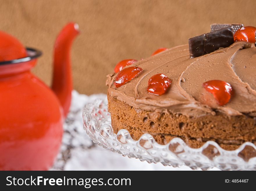 Chocolate cake with a red tea pot