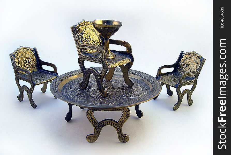 Three chairs, on of which on top of a table with chalice representing success. Three chairs, on of which on top of a table with chalice representing success