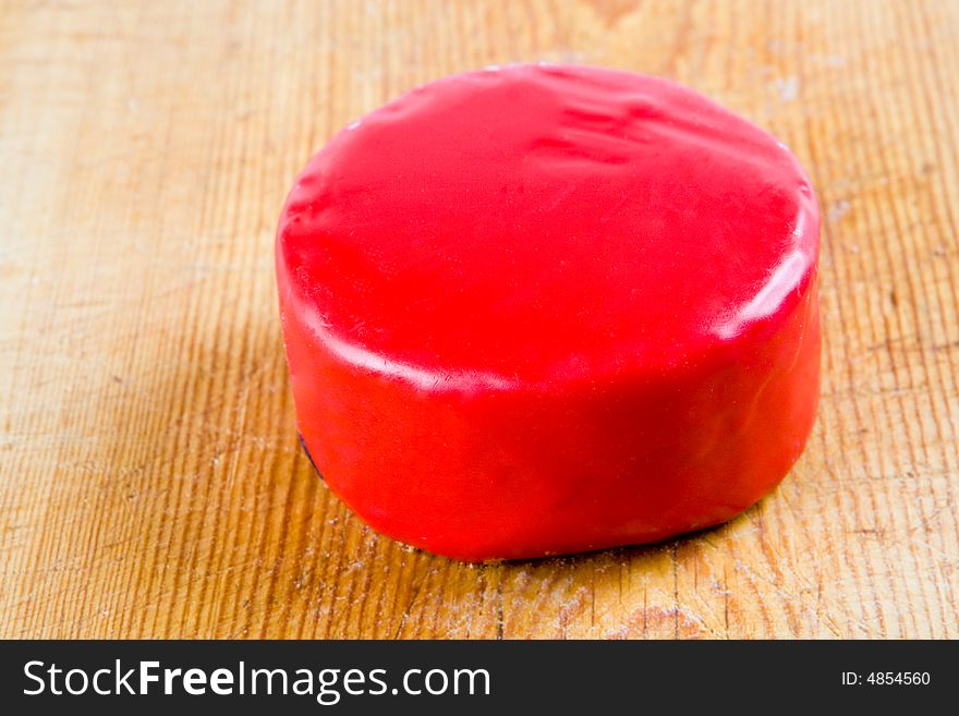 Cheese in red wax on a wooden board