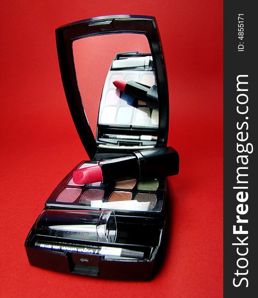 Red lipstick over opened makeup kit. Red lipstick over opened makeup kit