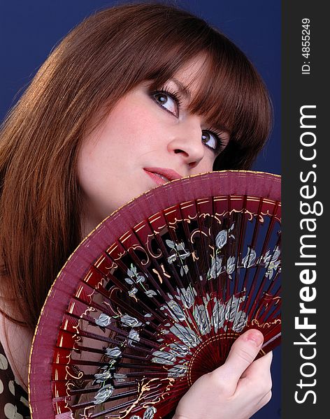 Close up portrait of cute young lady fanning herself with decorative spanish fan. Close up portrait of cute young lady fanning herself with decorative spanish fan