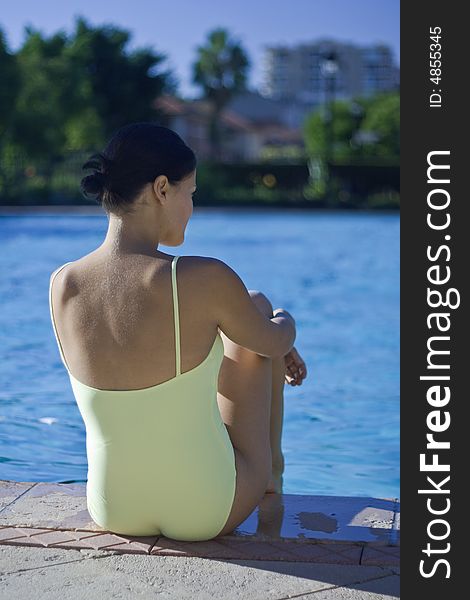 Girl sitting by the swimming pool. Girl sitting by the swimming pool