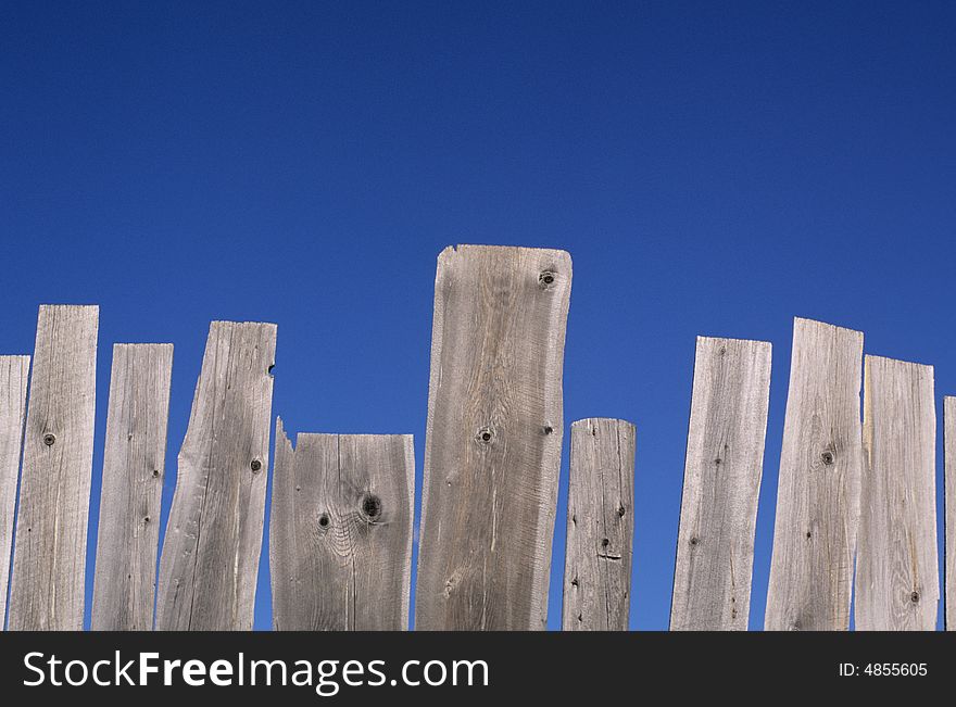 Weathered Fence And Blue Sky