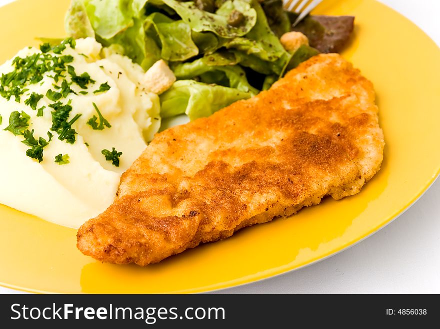 Viennese Schnitzelwith puree potatoes,salad and onion.