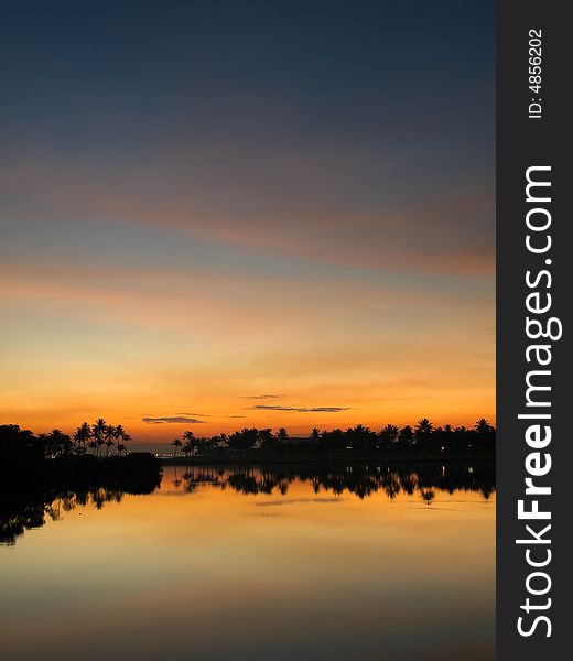 Tropical Holiday Island Resort at sunset reflected over a lake at a golf course. Tropical Holiday Island Resort at sunset reflected over a lake at a golf course