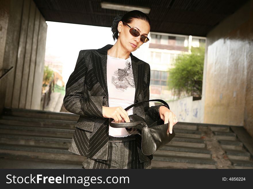 Attractive woman in a suit posing on the stairway. Attractive woman in a suit posing on the stairway