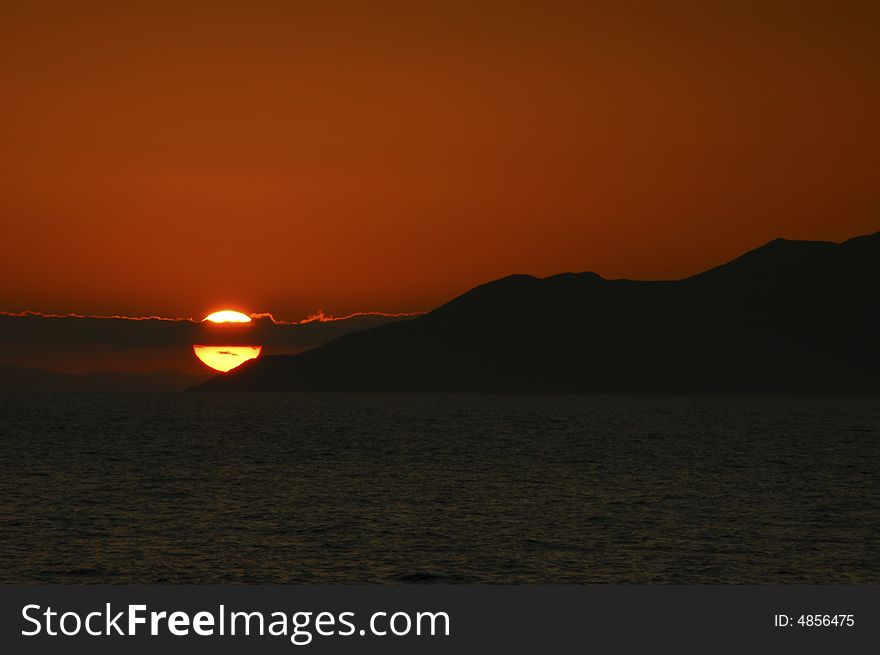 Sunset over Galapagos with the cloud spliting the sun showing two tones of yellow