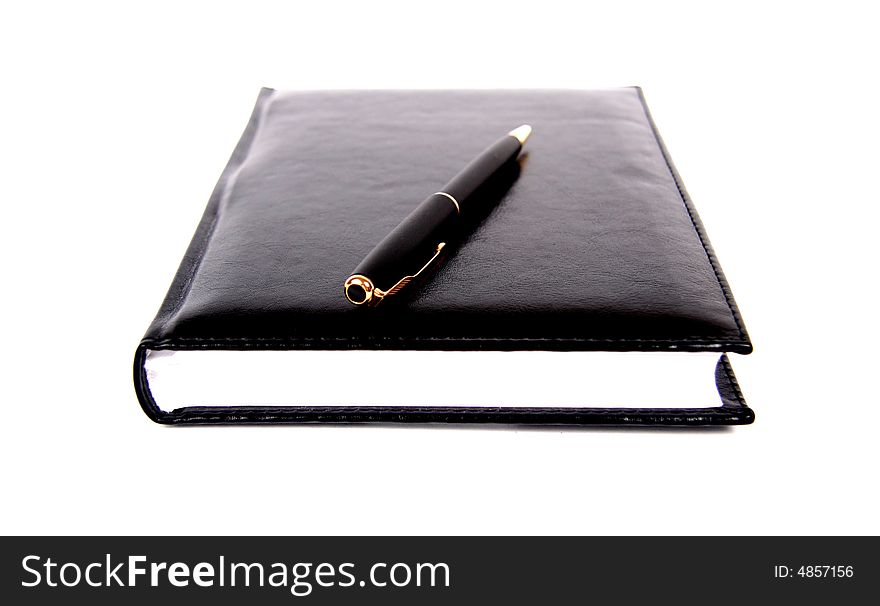 Black material notebook with pen isolated on white. Black material notebook with pen isolated on white.