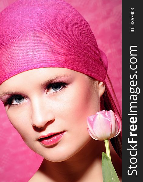 Beauty portrait of a beautiful young woman with a pink tulip flower. Beauty portrait of a beautiful young woman with a pink tulip flower
