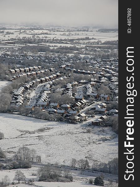 Taken from an areoplane the town is covered in  white snow. Taken from an areoplane the town is covered in  white snow