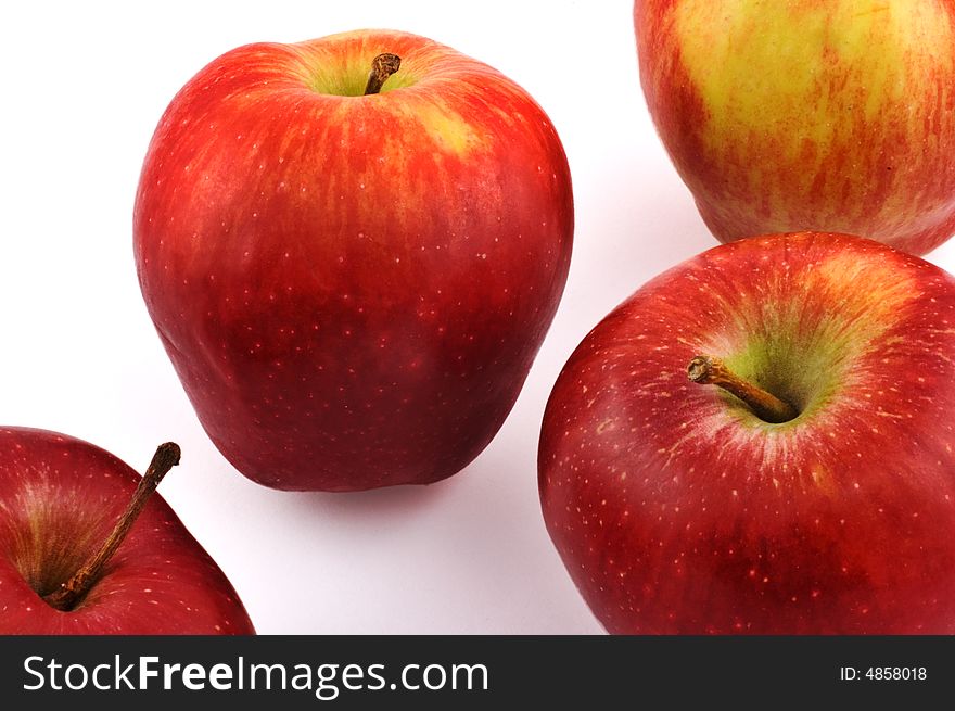 Four red apples scattered on white background