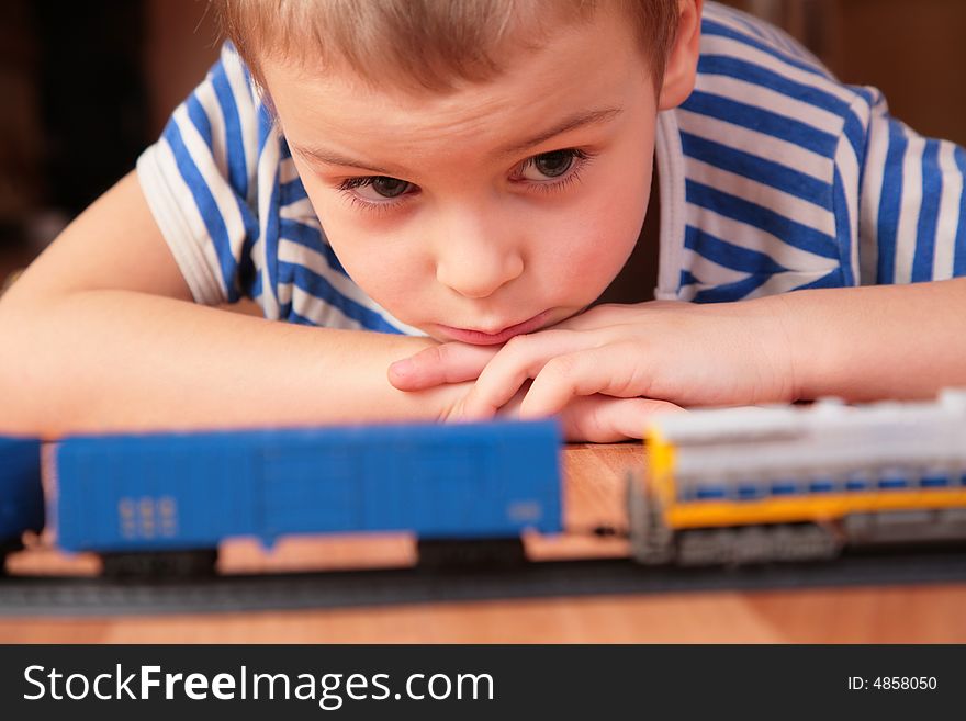 Boy Looks At Toy Railroad