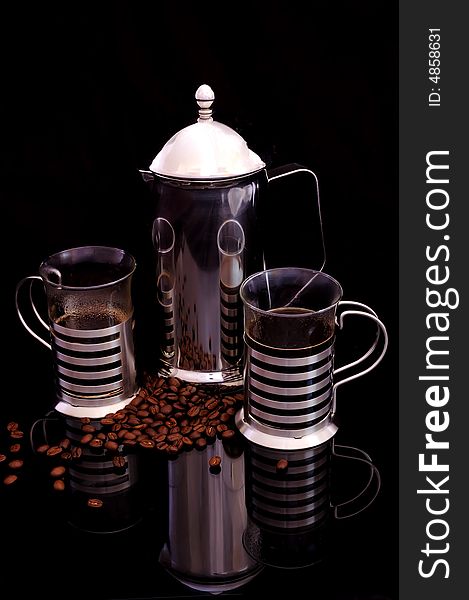 Stainless steel Coffee pot and cups with coffee beans in reflective surface isolated on black. Stainless steel Coffee pot and cups with coffee beans in reflective surface isolated on black
