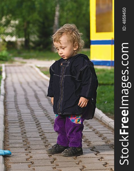 Small Curly Boy Stand On A Roadway