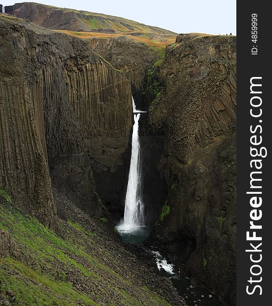 Tall Waterfall with basalt columns in Iceland. Tall Waterfall with basalt columns in Iceland