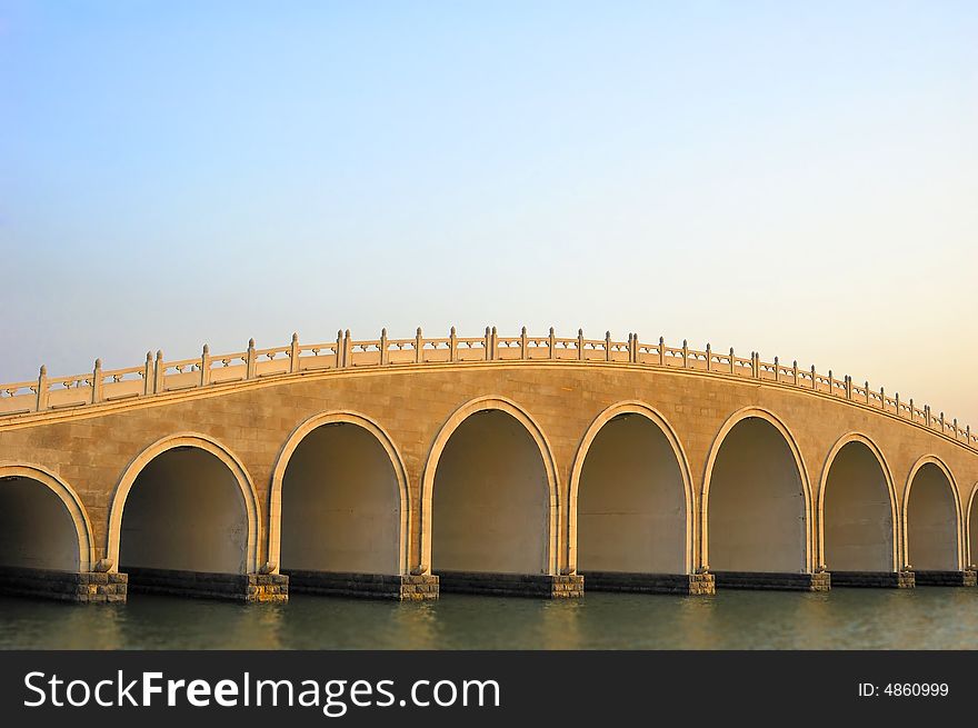 Stone arch bridge at sunset time