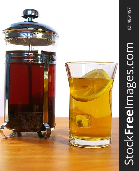 Black tea whith lemon in the transparent mug and kettle. Black tea whith lemon in the transparent mug and kettle