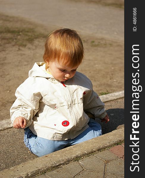 Little girl plays on the street