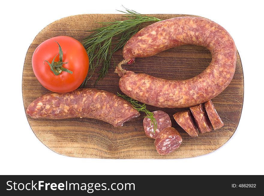 Sausage with tomato and dill on a wooden hardboard isolated on white