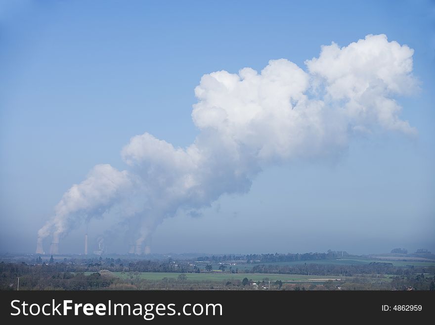 Power station bellowing emitting smoke from chimneys