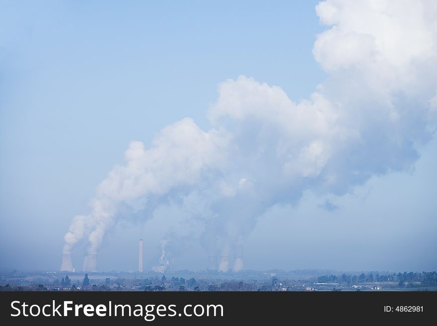 Power station bellowing emitting smoke from chimneys