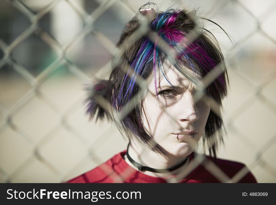 Young Punk Girl Being Shadowed By Chain Link. Young Punk Girl Being Shadowed By Chain Link