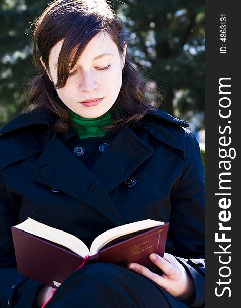 Young woman enjoying a book in the park. Young woman enjoying a book in the park