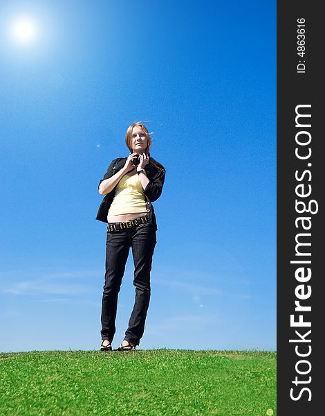 The young attractive girl with headphones on a background of the blue sky