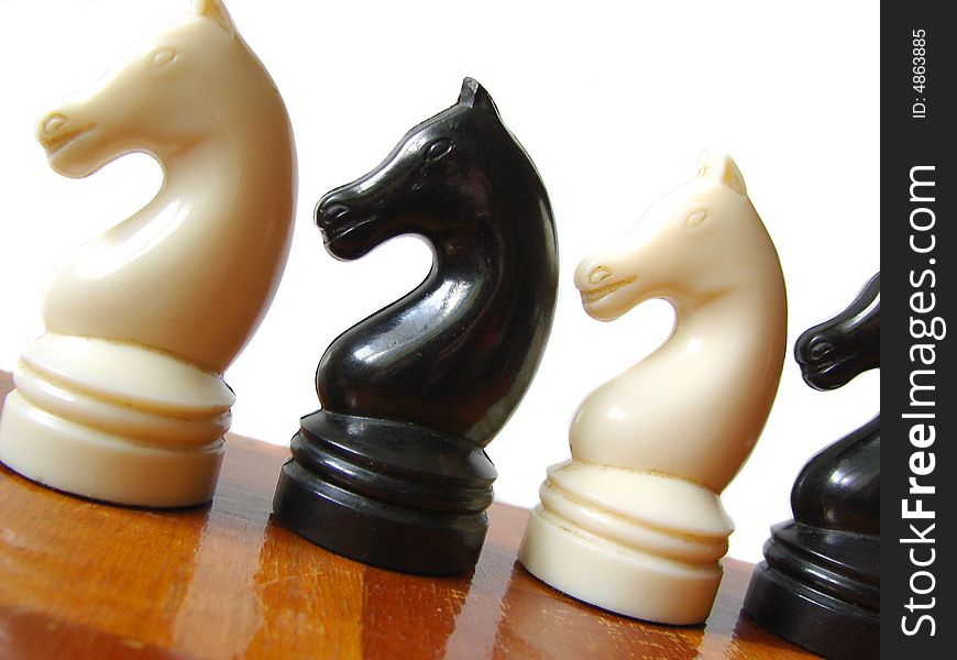 Black and white chess figures at checkerboard. Black and white chess figures at checkerboard