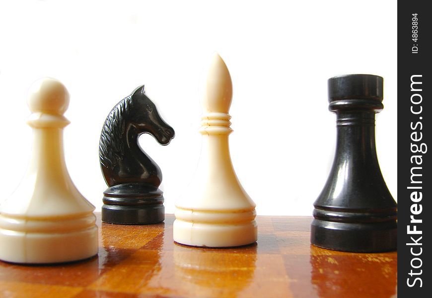 Black and white chess figures at checkerboard. Black and white chess figures at checkerboard