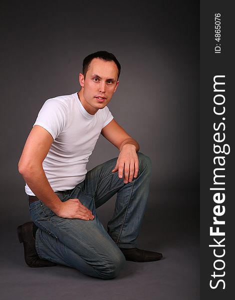 Portrait of young man in studio on dark background. Portrait of young man in studio on dark background