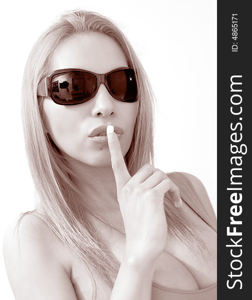 Shot of a young latin girl with sunglasses saying sshh. Shot of a young latin girl with sunglasses saying sshh