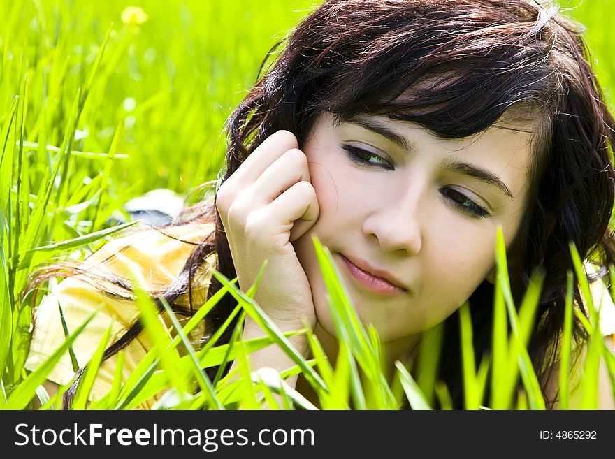 Pensive woman portrait over the grass. Pensive woman portrait over the grass
