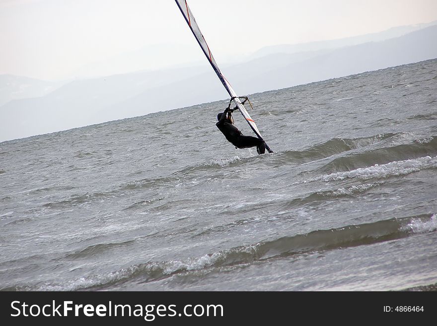 Windsurfing in winter,  snow on the surrounding hills