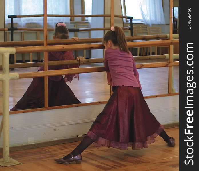 The girl-teenager near a mirror at ballet school. The girl-teenager near a mirror at ballet school