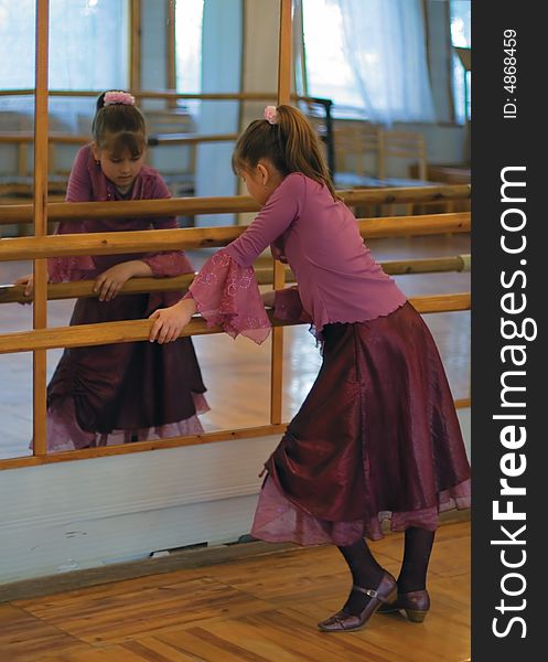 The girl-teenager near a mirror at ballet school. The girl-teenager near a mirror at ballet school