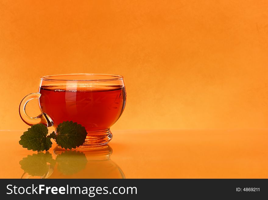 Cup of tea over orange background