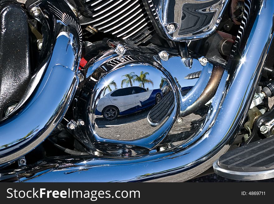 Reflection of custom painted car in motorcycles chrome motor parts. Reflection of custom painted car in motorcycles chrome motor parts