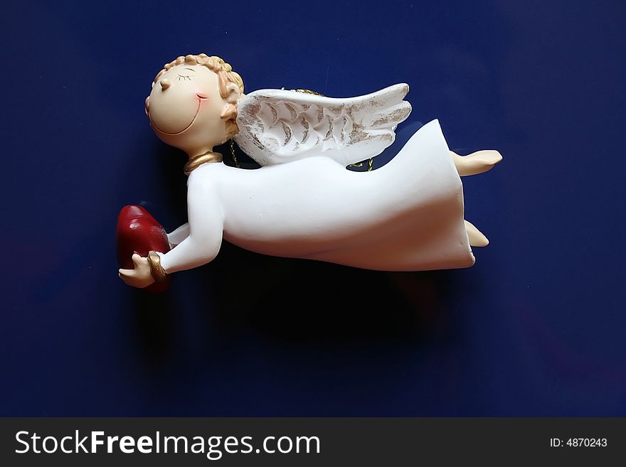 Cheerful doll-angel with heart in hands. Cheerful doll-angel with heart in hands.