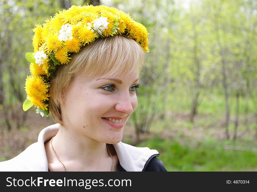 Smiling girl with a wreath from dandelions. Smiling girl with a wreath from dandelions