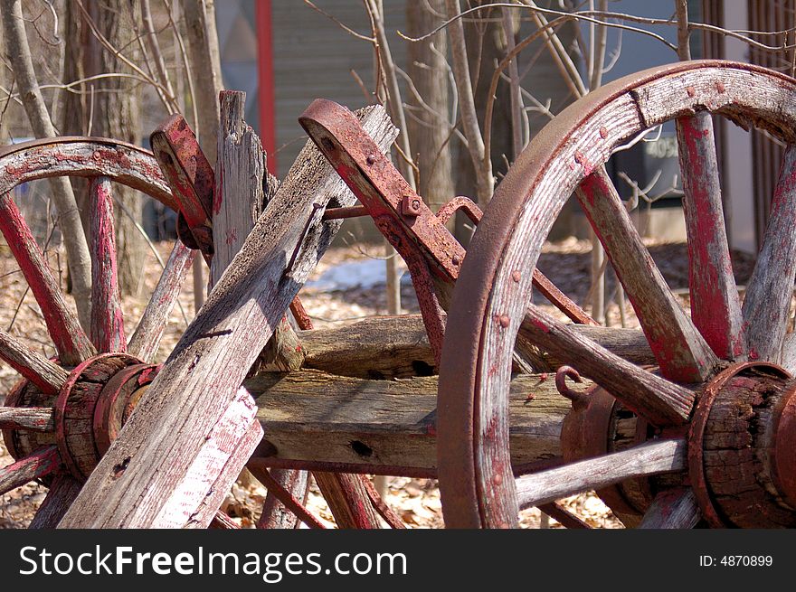 An image of a couple of old wheels from a broken cart. An image of a couple of old wheels from a broken cart.