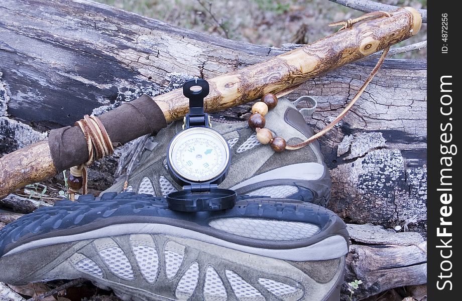 This is a picture of a walking stick, hiking shoes and a compass. This is a picture of a walking stick, hiking shoes and a compass.