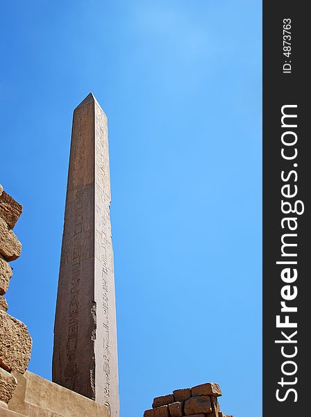 Egyptian obelisk with hieroglyphs on the blue sky